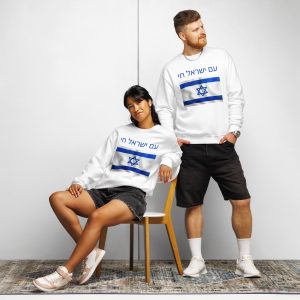 A man and woman wearing matching white sweatshirts with Hebrew "Am Yisrael Chai" text and an Israeli flag design, posing together in a casual studio setting.