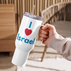 A hand holding a white travel mug with a handle and clear lid, featuring the text “I Love Israel” in blue and red, set against a warm indoor background.