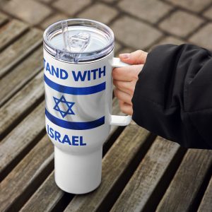 A hand holding a white travel mug with a handle and clear lid. The mug features blue text “I Stand With Israel” and an Israeli flag design, photographed outdoors on a wooden bench.