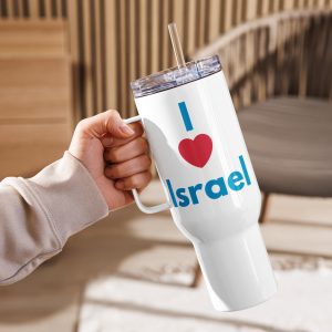 A hand holding a white travel mug with a handle and clear lid, featuring the text “I Love Israel” in blue and red, set against a warm indoor background.