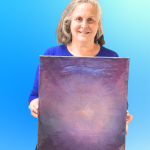 Rikki Rose holding one of her paintings