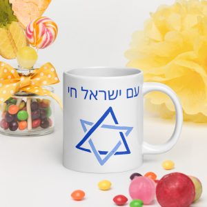 White mug with Hebrew “Am Yisrael Chai” text and Star of David design on a colorful decorative background.