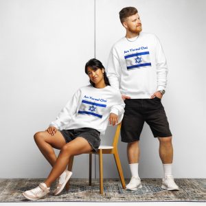 A man and a woman wearing white ‘Am Yisrael Chai’ sweatshirts with Israel Flag design, one sitting and one standing
